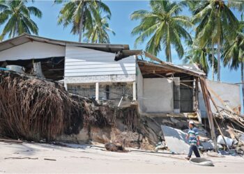 GHAZALI Mohamad meninjau keadaan kedai makanannya yang terjejas  teruk akibat hakisan pantai di Kampung Tanjung, Batu Rakit, Terengganu. – UTUSAN/PUQTRA HAIRRY