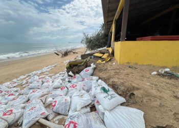 GUNI pasir terpaksa digunakan sebagai ikhtiar mengadang ombak di kilang keropok Pantai Pachakan, Pasir Puteh, Kelantan. - UTUSAN/TOREK SULONG