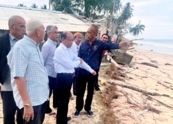 MOHD. Roshdi Ismail (dua dari kiri) bersama pemimpin setempat meninjau kemusnahan Pantai Bisikan Bayu, Pasir Puteh, Kelantan. - UTUSAN/TOREK SULONG