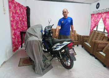 AMIR Hamzah menunjukkan motosikal anaknya yang kini disimpan 
dalam rumah selepas pernah disimbah minyak tanah oleh seorang lelaki bertopeng di Kampung Tiak, Kupang, Baling.