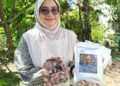 nurul Amirah Yahya menunjukkan produk pes dan salai keluaran syarikatnya.