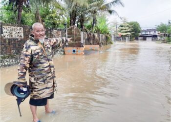 HARUN Samsudin menunjukkan kawasan perumahan di Taman Aman yang dinaiki air banjir sejak semalam.