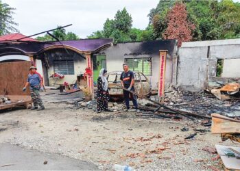 ZAMRI Ahmad dan isterinya, Nurul Wahida Md Saad melihat kesan kebakaran yang dikatakan bermula daripada motosikal yang berada di hadapan rumah mereka di Kampung Bukit Terabak, Kupang, Baling.