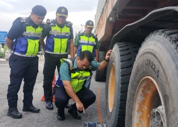 MUHAMMAD Kifli Ma Hassan (depan) memeriksa muatan lori treler yang ditimbang di JPJ Cawangan Taiping hari ini. - UTUSAN/WAT KAMAL ABAS