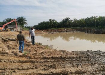 PENDUDUK menunjukkan kunci air yang dalam pembinaan
di Labu Kubong di Pasir Salak. – UTUSAN/AIN SAFRE BIDIN