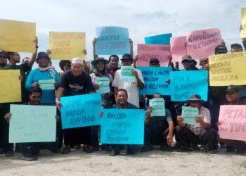 PESAWAH yang mengadakan perhimpunan sebagai membantah penurunan harga belian padi di Kampung Sungai Bakau di Parit Buntar semalam. - UTUSAN/WAT KAMAL ABAS