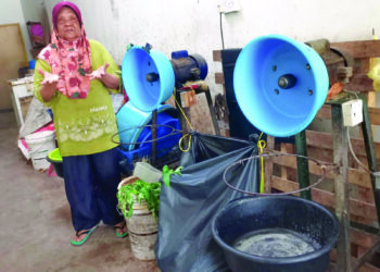 NORAINI Saat menunjukkan keadaan di ruang mesin kelapa yang kehabisan stok kelapa di kedai santan yang diusahakannya di Kampung Bahagia di Teluk Intan. - UTUSAN/AIN SAFRE BIDIN