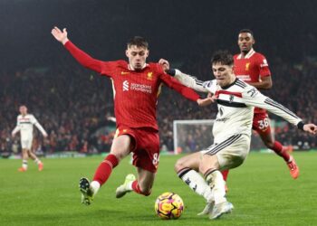 Pertahanan Liverpool,  Conor Bradley (kiri) bersaing dengan pemain tengah Manchester United,  Alejandro Garnacho dalam saingan Liga Perdana Inggeris di Anfield pagi ini. - AFP