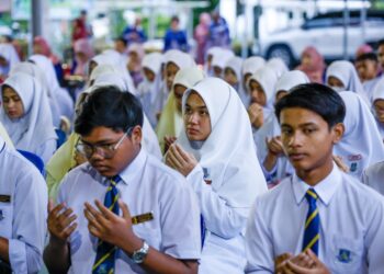 PELAJAR mengaminkan bacaan doa sebelum menduduki peperiksaan SPM di SMK Kampung Pasir Puteh, di Ipoh hari ini. - UTUSAN/MUHAMAD NAZREEN SYAH MUSTHAFA