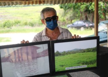 JOHENG Lah menunjukkan dua gambar Tasik Mentiga asal (kiri) dan kini penuh dengan rumput rampai menjadi faktor tasik semakin kering di Pekan, Pahang.