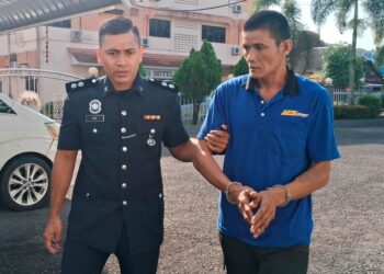 MOHD. Hanafi Ngah diiring polis keluar dari Mahkamah Majistret Kemaman, Terengganu. - UTUSAN/NIK NUR IZZATUL HAZWANI NIK ADNAN