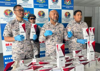 ERWAN Shah Soahdi (tengah) menunjukkan sebahagian rokok putih yang dirampas di Pejabat Maritim Malaysia Kelantan di Tok Bali, Pasir Puteh, semalam. - UTUSAN/TOREK SULONG