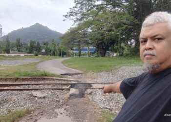 MOHD. Saferi Salleh menunjukkan kawasan lintasan haram jalan kereta api yang digunakan  penduduk berdekatan pekan Mela di Mela, Lipis, Pahang. - UTUSAN/HARIS FADILAH AHMAD