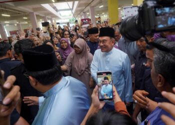 ANWAR Ibrahim beramah mesra dengan mahasiswa ketika hadir menjamu selera di Anjung Dengkil, UiTM Dengkil, semalam. – UTUSAN/FAISOL MUSTAFA