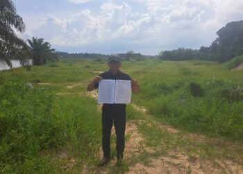 MOHAMED Zainudin Ibrahim menunjukkan memorandum bantahan penduduk bagi cadangan satu lagi operasi pam pasir di Sungai Perak di Kampung Tanjung Aur dekat Bota di Parit, Perak.