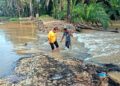 PENDUDUK menunjukkan keadaan ban pecah menyebabkan air Sungai Kinta melimpah ke kawasan kebun sawit berdekatan di  Kampung Permatang Pelandok di Pasir Salak. - UTUSAN/AIN SAFRE BIDIN