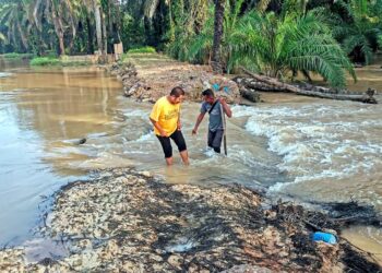 PENDUDUK menunjukkan keadaan ban pecah menyebabkan air Sungai Kinta melimpah ke kawasan kebun sawit berdekatan di  Kampung Permatang Pelandok di Pasir Salak. - UTUSAN/AIN SAFRE BIDIN