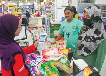 PENERIMA Program Sumbangan Asas Rahmah (SARA) membeli barangan keperluan harian dengan menggunakan kad pengenalan ketika tinjauan di sebuah pasaraya. - GAMBAR HIASAN