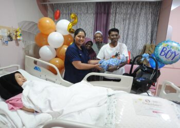 MOHAMMED FAZURUL Rahman mendukung bayi lelakinya yang lahir  pada 1 Januari sambil diperhatikan Dr. S. Deepa di samping isterinya, Nur Atila Abd. Rahman di Hospital Pakar KPJ Puteri, Johor Bahru.