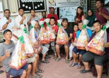 NELAYAN yang menerima hamper sempena perayaan Krismas dan sambutan tahun baharu bergambar kenangan di Pusat Perkhidmatan Setempat Nelayan (PPSN) di Permatang Damar Laut, Bayan Lepas, Pulau Pinang