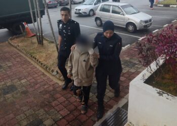 REMAJA perempuan berusia 14 tahun (tengah) yang didakwa mencederakan ibu saudaranya sendiri diiringi oleh dua anggota polis ketika tiba di Mahkamah Majistret Bukit Mertajam, Pulau Pinang, hari ini.-UTUSAN/IQBAL HAMDAN