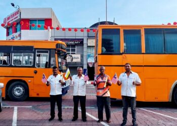 P.  SELVARAJO  (dua dari kiri) bersama pemandu bas sekolah daerah Hilir Perak ketika ditemui di Teluk Intan, Perak, semalam. - UTUSAN/AIN SAFRE BIDIN.