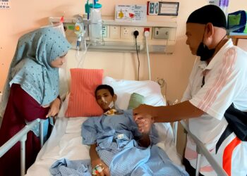 ADNAN Ali (kanan) dan Siti Mariam Mohd. Zain menjaga Muhamad Bahaman ketika dirawat di Hospital Sultan Haji Ahmad Shah di Temerloh, Pahang. – UTUSAN/HARIS FADILAH AHMAD