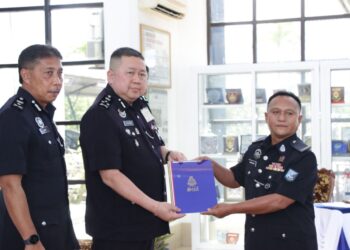 KHAW Kok Chin (tengah) menyampaikan sijil penghargaan kepada salah seorang pegawai PDRM Briged Sabah PGA, di Kinarut Papar, hari ini