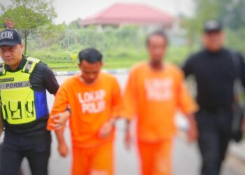 TERTUDUH (dua dari kanan) diringi polis semasa menghadiri prosiding perbicaraan di Mahkamah Sesyen Kota Bharu, Kelantan hari ini-UTUSAN/ROSLAWANI CHE SOH.