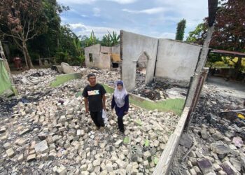 IBRAHIM Ali bersama isterinya melihat kesan kebakaran rumah mereka akibat perbuatan khianat di Kampung Tanah Periuk, Kupang di Baling.