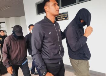 KEDUA-DUA tertuduh diiringi anggota Suruhanjaya Pencegahan Rasuah Malaysia (SPRM) semasa dihadapkan ke Mahkamah Sesyen Ayer Keroh, Melaka.