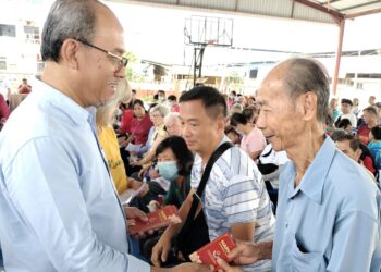 MD. JAIS SARDAY (kiri) menyampaikan angpau sumbangan Yayasan Prihatin Kluang (YPK) dalam Majlis Penyampaian Sumbangan sempena Tahun Baharu Cina di Kluang, hari ini.