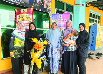 NURHANAN Aminuddin (dua dari kiri) bersama Noor Haslina Abdullah pada majlis penyerahan motosikal di Amkist, Bachok, Kelantan. 
– UTUSAN/TOREK SULONG