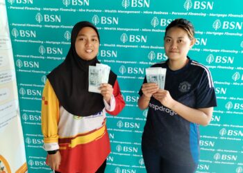 SITI Humairah Atiqah Bakhtiar (kiri) dan Suhana Ismail menunjukkan 
sumbangan STR berjumlah RM150 di Bank Simpanan Nasional (BSN) Jalan Munshi 
Abdullah, Melaka. -UTUSAN/AMRAN MULUP