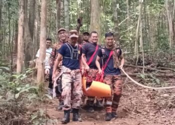 ANGGOTA Balai Bomba dan Penyelamat Kluang membawa turun Fudhayl Ar Rizqin Riduan yang patah tangan ketika menuruni Gunung Lambak di Kluang, pagi tadi.