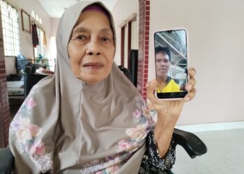 ESAH Mohamad menunjukkan gambar Rosenizam yang membuat panggilan video dengan Ahli Dewan Undangan Negeri (ADUN) Telok Mas, Datuk Abdul Razak Abdul Rahman di Permatang Pasir, Melaka, semalam. UTUSAN/AMRAN MULUP.