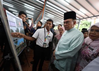 ANWAR  Ibrahim beramah mesra dengan peniaga-peniaga di Pusat Wirawati Penjaja, hari ini. GAMBAR: FARIZ RUSADIO