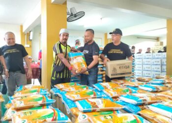  ZAWAHIR Abdullah (kiri) bersama Pengarah Wilayah Pantai Timur Etiqa Insurans & Takaful, Muhamad Nurawi Abdul Rashid (dua dari kanan) menyampaikan pek makanan kepada salah seorang mangsa banjir di Masjid Mukim Lubok Setol, Rantau Panjang, Kelantan. - UTUSAN/ROHANA ISMAIL