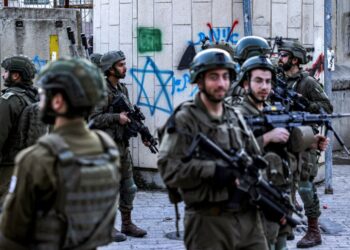 ASKAR Israel berkawal ketika peneroka Yahudi melawat pasar lama di bandar Hebron di Tebing Barat, pada 28 Disember 2024.- AFP