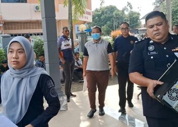 AZAM Hashim (tiga dari kanan) diiring pegawai Kementerian Dalam Negeri (KDN) dan polis keluar dari Mahkamah Majistret Kemaman, Terengganu. - UTUSAN/NIK NUR IZZATUL HAZWANI NIK ADNAN