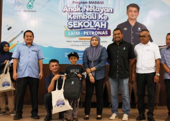 MUHAMMAD Faiz Fadzil (tiga dari kiri) menyerahkan sumbangan kepada anak nelayan pada program Kembali ke Sekolah 2025 anjuran Lembaga Kemajuan Ikan Malaysia dan Petronas di Kuala Nerus, Terengganu. - UTUSAN/PUQTRA HAIRRY