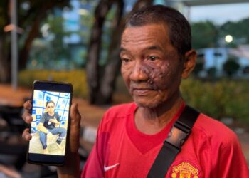 MOHD Zaini Hashim menunjukkan gambar anaknya, Muhammad Muslim yang dipercayai rentung dalam kebakaran rumah di Jalan Kota Tanah, Tongkang Yard di Alor Setar.