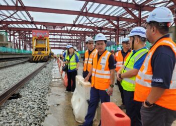 DARWIS Abdul Razak (tiga dari kanan) melihat perkembangan kerja pemasangan landasan ECRL dari Maran, Pahang ke Kota Bharu di stesen pertama projek mega itu di Tunjung, Kota Bharu, Kelantan hari ini. - UTUSAN/MUSTAQIM MOHAMED