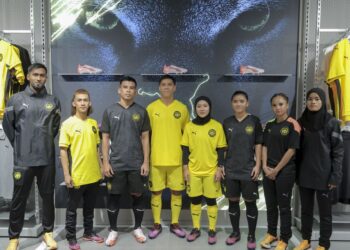 Pemain lelaki dan wanita kebangsaan memperagakan jersi baharu pada majlis menandatangani perjanjian antara PUMA Malaysia dengan Persatuan Bola Sepak Malaysia (FAM) di Subang Jaya, semalam, - UTUSAN/FARIZ RUSADIO