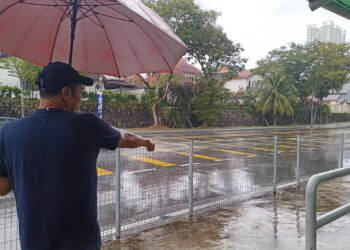 AHMAD menunjukkan lokasi tempat kereta BMW dinaiki mangsa dan anak perempuannya berhenti berhadapan sekolah di Bandar Baru Uda, Johor Bahru.