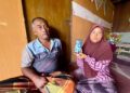 NAZIROH Saad di samping adiknya, Saiful, 49, menunjukkan gambar adik mereka, Siti Rohani di Kampung Kuala Lanjut, Pendang.