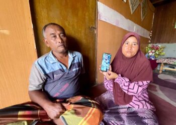 NAZIROH Saad di samping adiknya, Saiful, 49, menunjukkan gambar adik mereka, Siti Rohani di Kampung Kuala Lanjut, Pendang.