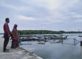 HALIMAH Saari ditemani anaknya, Asmawadi Zainol berada di jeti Kampung Pengkalan Batu Lintang untuk menunggu perkembangan kes kehilangan anak dan cucunya di Tikam Batu, Sungai Petani.