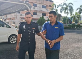 MOHD. Hanafi Ngah diiring polis keluar dari Mahkamah Majistret Kemaman, Terengganu. - UTUSAN/NIK NUR IZZATUL HAZWANI NIK ADNAN