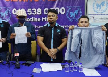 HISHAMUDDIN Hashim (tengah) bersama mangsa ceti haram, Azman (kiri) dan perunding MHO, Datuk Naimshamsul (kanan) menunjukkan laporan polis dan baju yang dirobek pada sidang akhbar berhubung aduan mangsa ceti haram yang ditipu dan diperdaya sehingga hampir di culik di sini hari ini. - UTUSAN/FAUZI BAHARUDIN